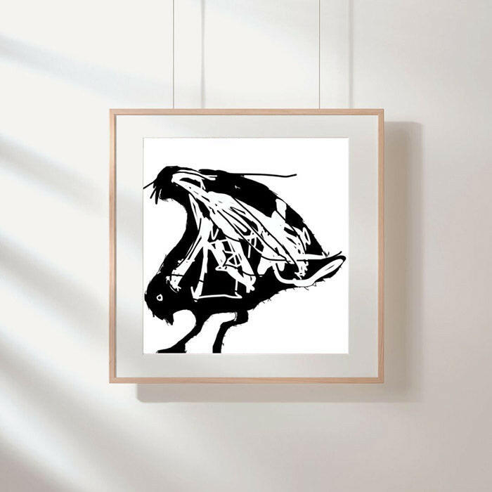 Printable wall art of an abstract seagull in black and white, framed in a square beige frame, on a white wall.