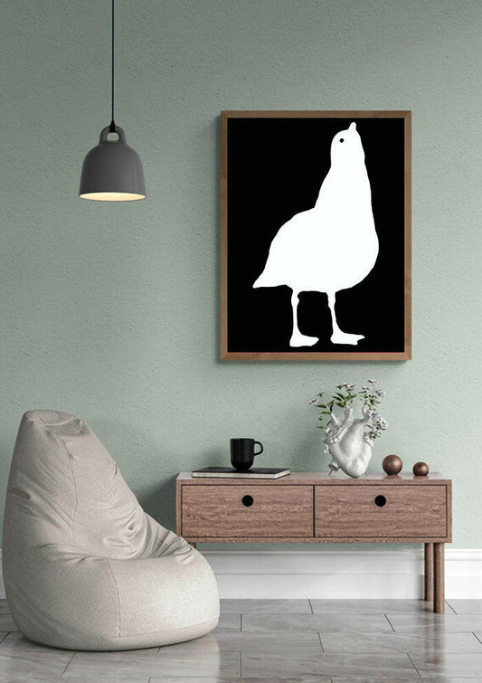 Framed artwork of a white seagull silhouette on a black background in a modern living room.