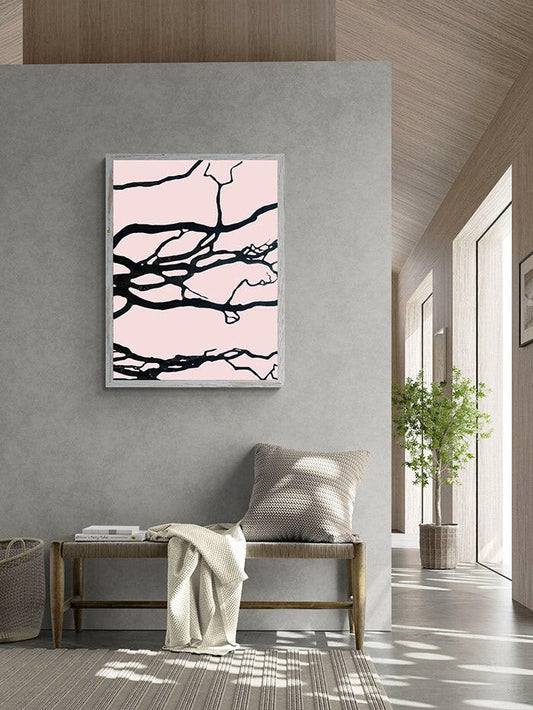 Abstract art print with black branches on a pink background in a modern interior setting.