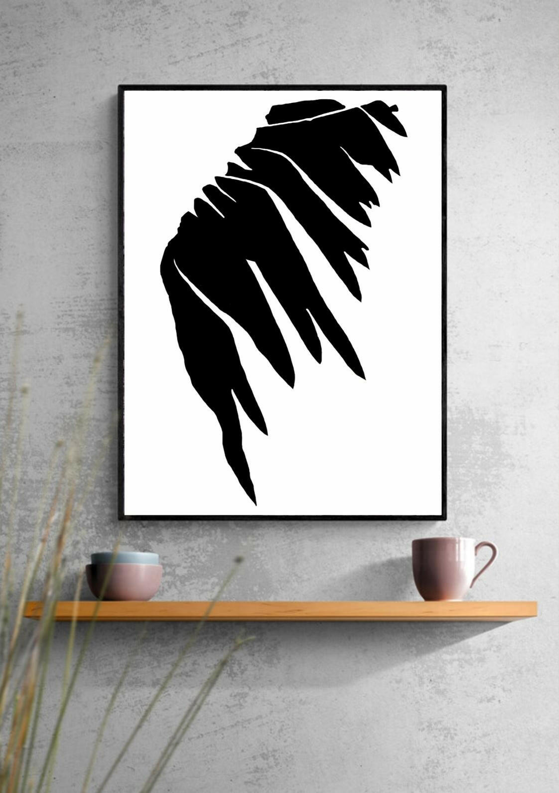 Framed black and white abstract art print on a gray wall with a wooden shelf below.