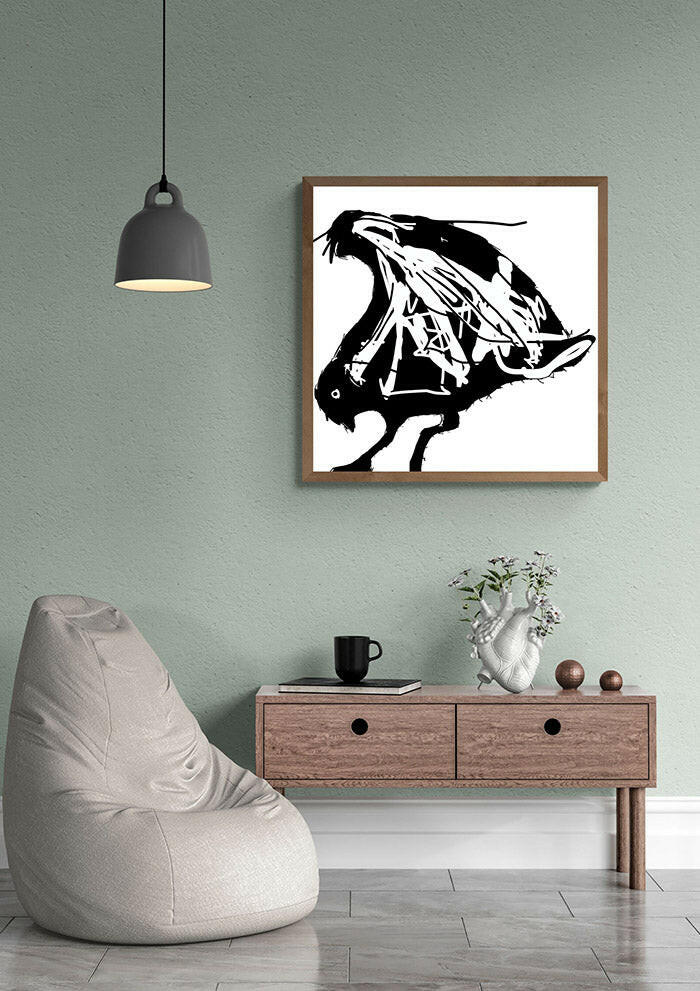 Modern interior with a bean bag chair, coffee table, and printable wall art of an abstract seagull in black and white framed on the wall.