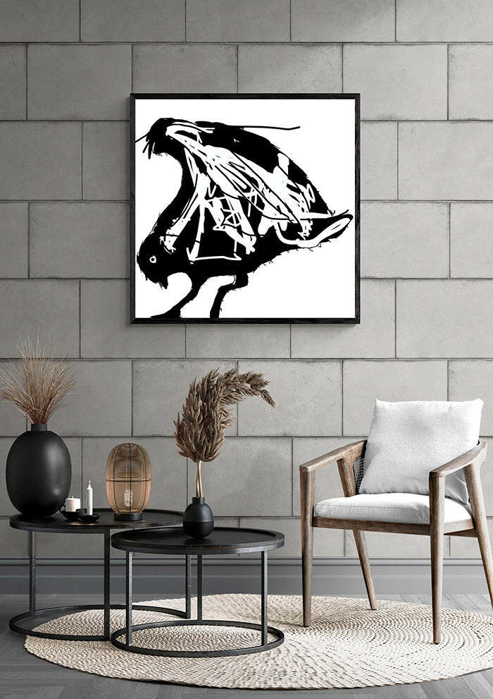 Modern living room with printable wall art of an abstract seagull in black and white, framed in black, on a grey wall.