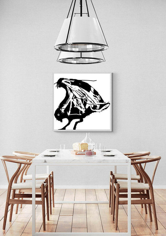 Dining room with printable wall art of an abstract seagull in black and white on the wall, wooden chairs, and a white table.
